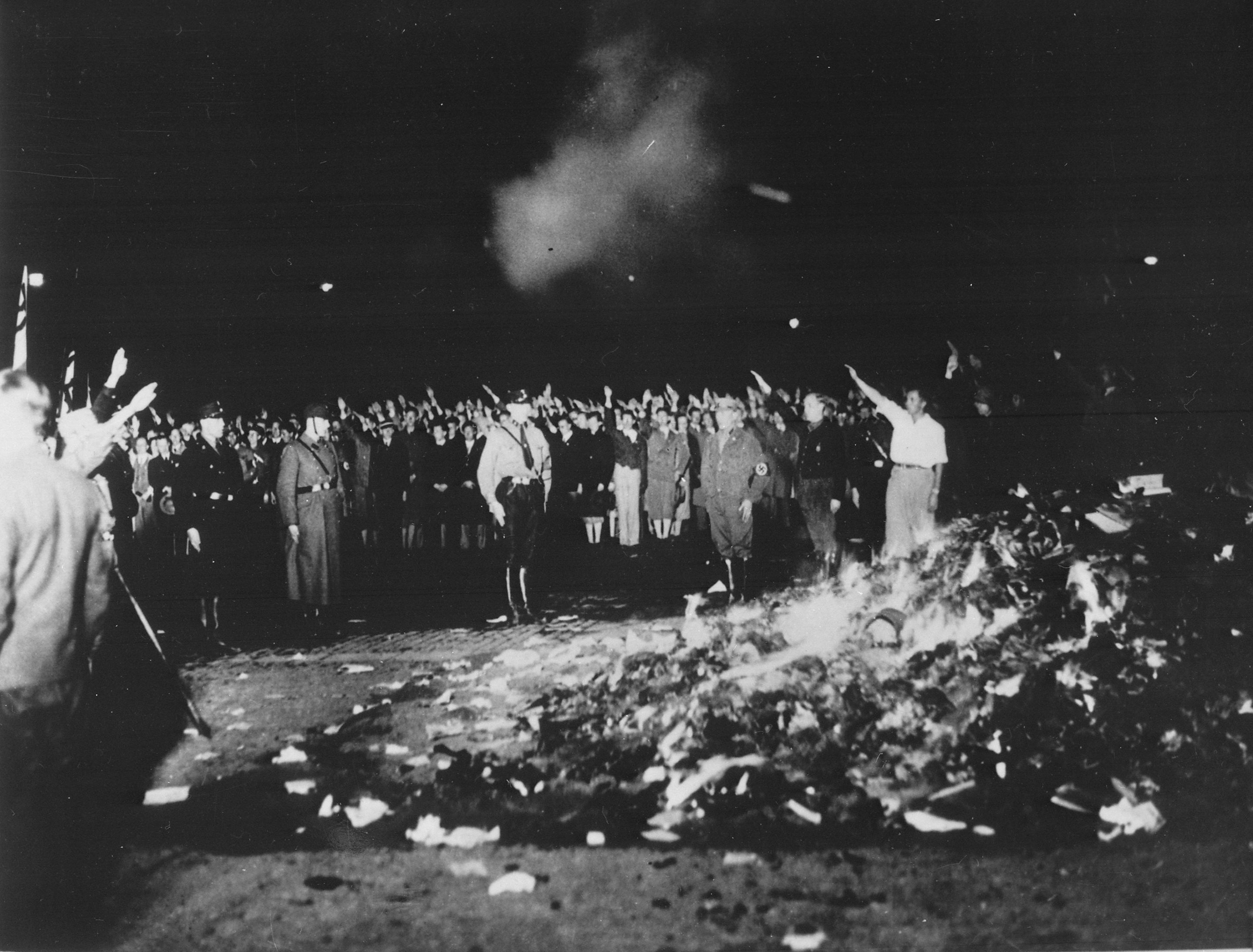 1933年5月10日，纳粹分子支配的德国大学生运动在柏林街头焚烧「非德意志」书籍。 恐惧无产阶级化，渴望维持社会地位和商业致富之道的小资产阶级，当年是诉诸本土保护主义、坚决反共排外的纳粹党的中坚支持者。 （Bundesarchiv, Bild 102-14597/Georg Pahl）